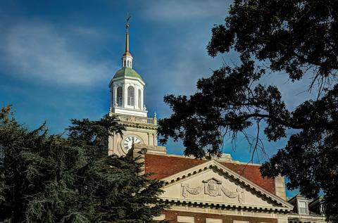 Chapel steeple with skies and trees in the background. 